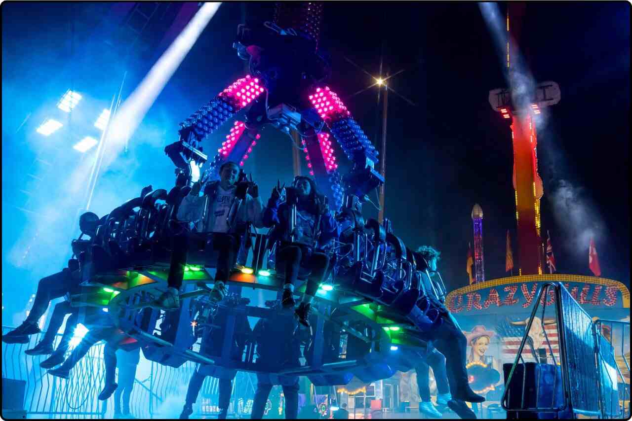 People having fun on a carnival ride with vibrant lights.